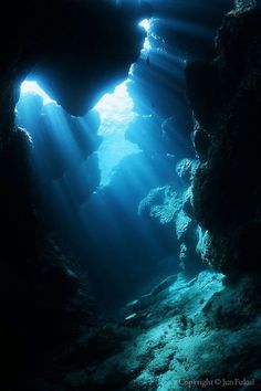 an underwater cave with sunlight streaming through the water