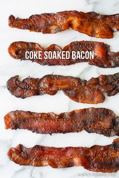 three bacon strips are lined up on a marble counter top with the words, coke soaked bacon