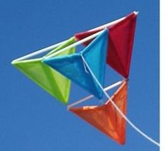 two kites are flying in the blue sky