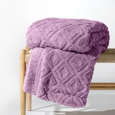 a purple blanket sitting on top of a wooden chair