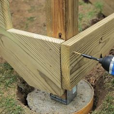 a drill is being used to fix a wooden post