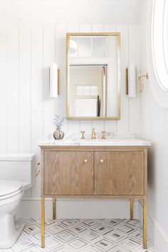 a bathroom with a sink, toilet and wooden cabinet in the middle of the room