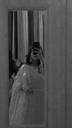 a woman taking a selfie in front of a mirror wearing a dress and holding a cell phone