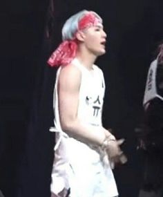 a young man with blue hair wearing a white shirt and red bandanna around his neck