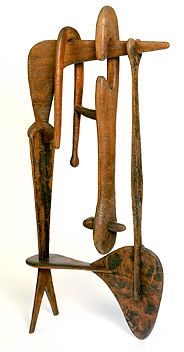 a wooden sculpture with two people on it's back and one holding an umbrella