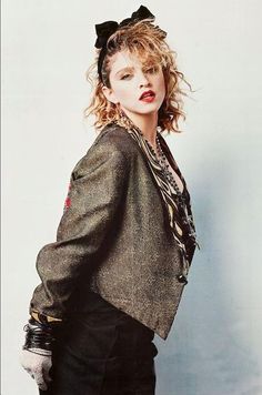 a woman with curly hair wearing a green jacket and black pants, posing for a magazine cover