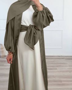 This puff sleeve satin open abaya is the perfect statement piece for any outfit in 5 beautiful colours. Wear with or without the matching belt for a stunning khaleeji look. Dresses In Dubai, Spring Workout, Open Abaya, Mode Abaya, Summer Cardigan, Summer Elegant, Hijabi Outfits, Abaya Dress, Bubble Sleeve