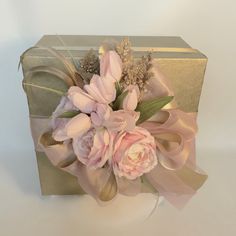 a bouquet of pink flowers sitting on top of a gold box