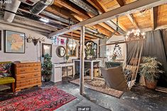 a living room filled with furniture and lots of wood beams on the ceiling, along with a hammock chair