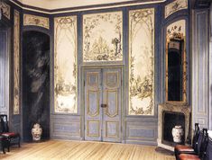 an ornate room with painted walls and wooden floors