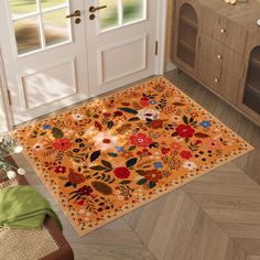 an orange rug with flowers on it in front of a white door and wooden floor