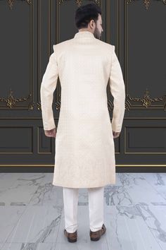 This men's sherwani (traditional Indian attire) features expertly crafted thread and sequin work. The intricate detailing adds a touch of elegance to any occasion. Made from high-quality materials, it offers both style and comfort. Perfect for those seeking a traditional yet sophisticated look. Ceremonial Elegant Semi-stitched Sherwani, Elegant Semi-stitched Sherwani In Straight Kurta Style, Elegant Designer Wear Sherwani With Straight Kurta, Elegant Sherwani With Zari Work Straight Kurta, Elegant Sherwani With Zari Work, Elegant Embroidered Sherwani Straight Kurta, Cream Sherwani With Chikankari Embroidery And Long Sleeves, Cream Long Sleeve Sherwani For Diwali, Cream Long Sleeve Sherwani With Chikankari Embroidery