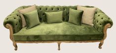 a green couch with many pillows on it