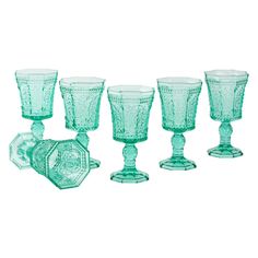 six green glass goblets and plates on a white background