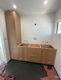 an unfinished kitchen with wooden cabinets and black flooring