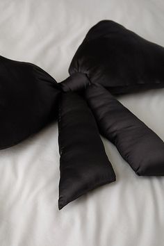 two black pillows tied to each other on a bed