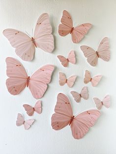 the pink butterflies are arranged on the wall