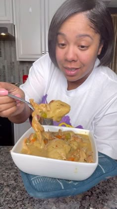 a woman eating food from a white bowl