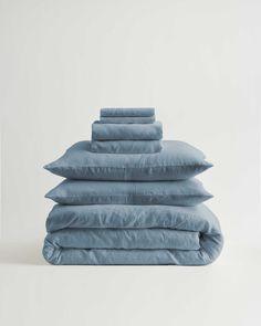 four blue pillows stacked on top of each other