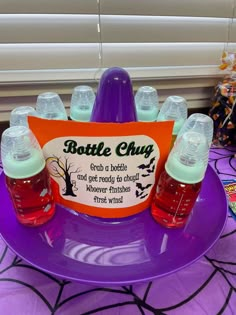 a purple plate topped with bottles of liquid and an orange sign that says bottle chug