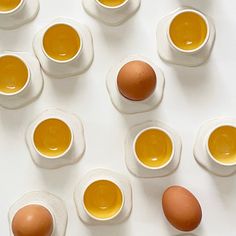 several eggs are arranged in rows next to each other, with one broken egg between them