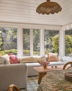 a living room filled with furniture and lots of windows