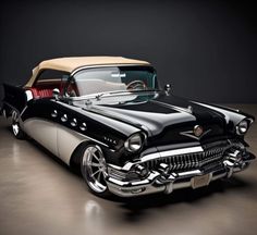 an old black and white car parked in a garage