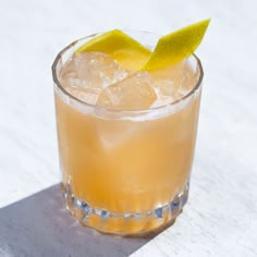 a close up of a drink in a glass with a lemon wedge on the rim