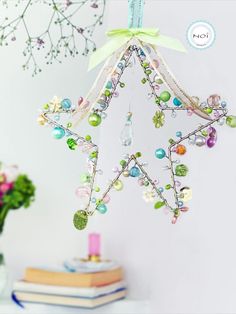 an ornament hanging from the side of a table next to books and flowers