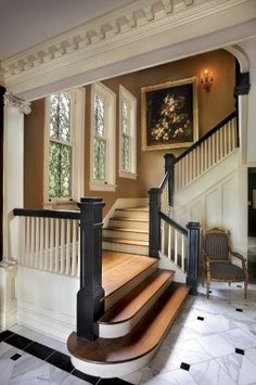 an elegant staircase in a home with white walls and black railings on either side