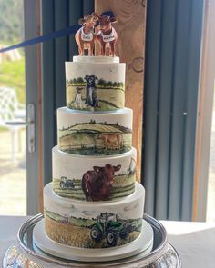 a three tiered cake decorated with farm animals