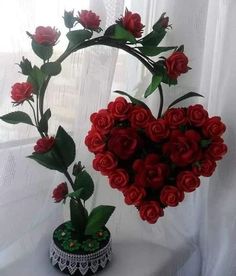 a heart shaped arrangement of red roses in a vase