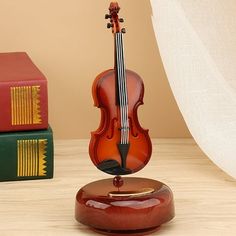 a violin on a stand next to some books