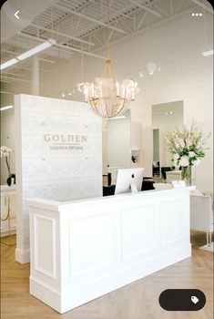 a white reception desk with a chandelier hanging from the ceiling