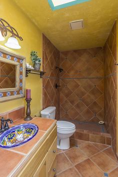 a bathroom with yellow walls and tile flooring