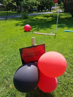 some red and black balloons are in the grass