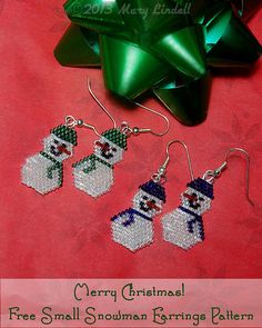 three pairs of beaded snowman earrings next to a green bow