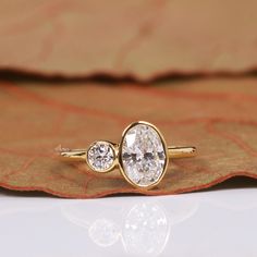 two diamond rings sitting on top of a leaf