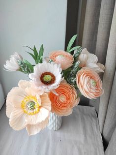 an arrangement of flowers in a vase on a table