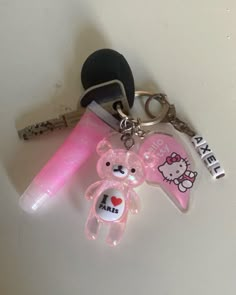 a pink key chain with two teddy bears on it and an i love you sticker