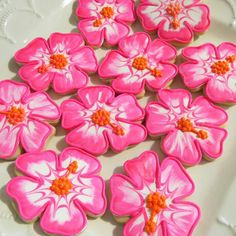 some pink flowers are on a white plate