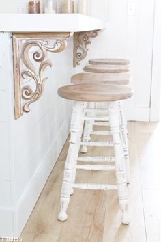 the stools are made out of wood and have been painted white with gold accents