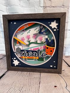 a wooden frame that has some art supplies in it and the words create on it