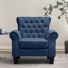 a blue chair sitting on top of a rug next to a table