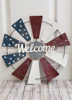 the welcome sign is made out of wood and has an american flag design on it