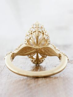 The Majesty captures the essence of old-world charm and intricate hand work. We sourced a beautiful marquise diamond and surrounded her with countless sparklers in timeless yellow gold setting. The intricate detail in every nook of this ring will show your love how much thought you've put into this token of promise. She pairs beautifully with our Gloria. Approx Band Width (mm): 3.2mm - 1.5mm Setting Diamond Quality (side stones): Colorless and VS clarity Approx Setting Total Carat Weight (side s Marquise Engagement Rings Gold, Marquise Diamond Ring Settings, Unique Marquise Engagement Ring, Marquise Engagement Ring Gold, Marquis Diamond, Marquise Diamond Ring, Marquise Shape Diamond, Peach Sapphire, Future Engagement Rings