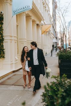 a man and woman are walking down the street