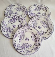 six purple and white plates with flowers on them