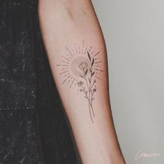 a woman's arm with a flower and sun tattoo on the left side of her arm