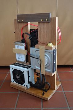 an electronic device is sitting on top of a wooden stand in the middle of a tile floor